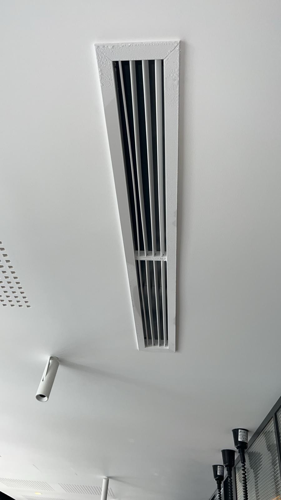 Grille linéaire de diffusion d’air intégrée dans un plafond à Paris